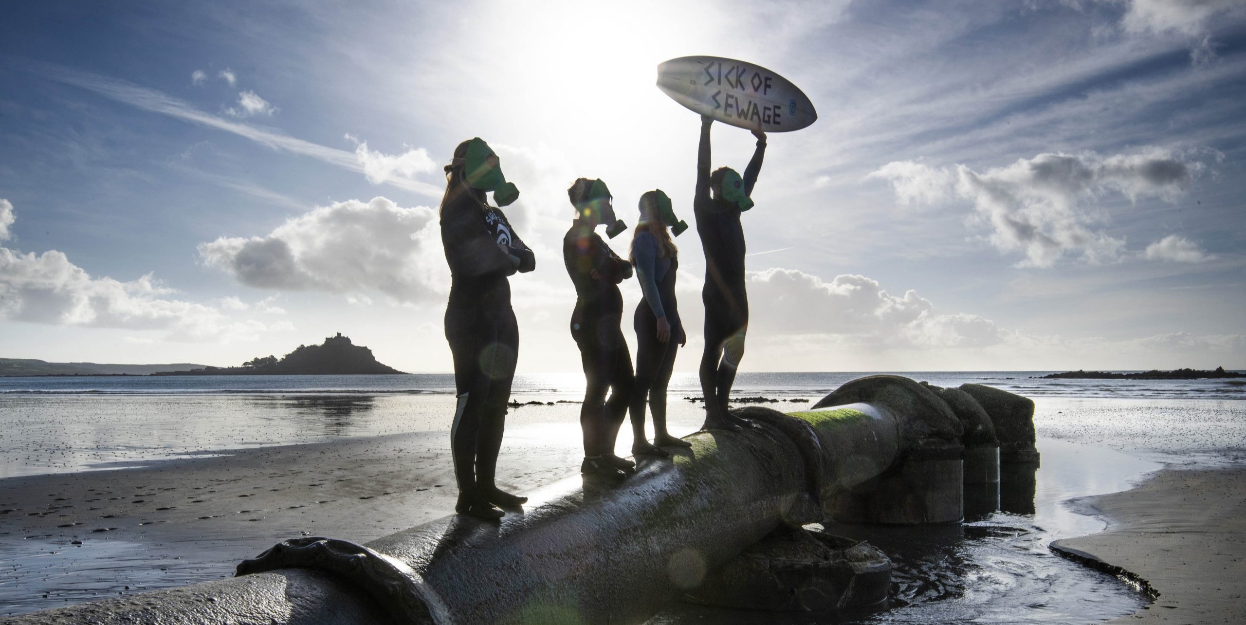 Campaigners standing on a sewage pipe