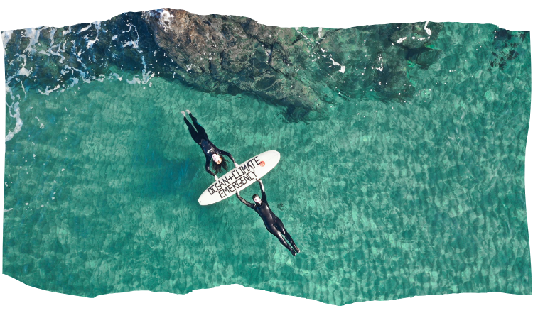 Activists lying in water with surfboard