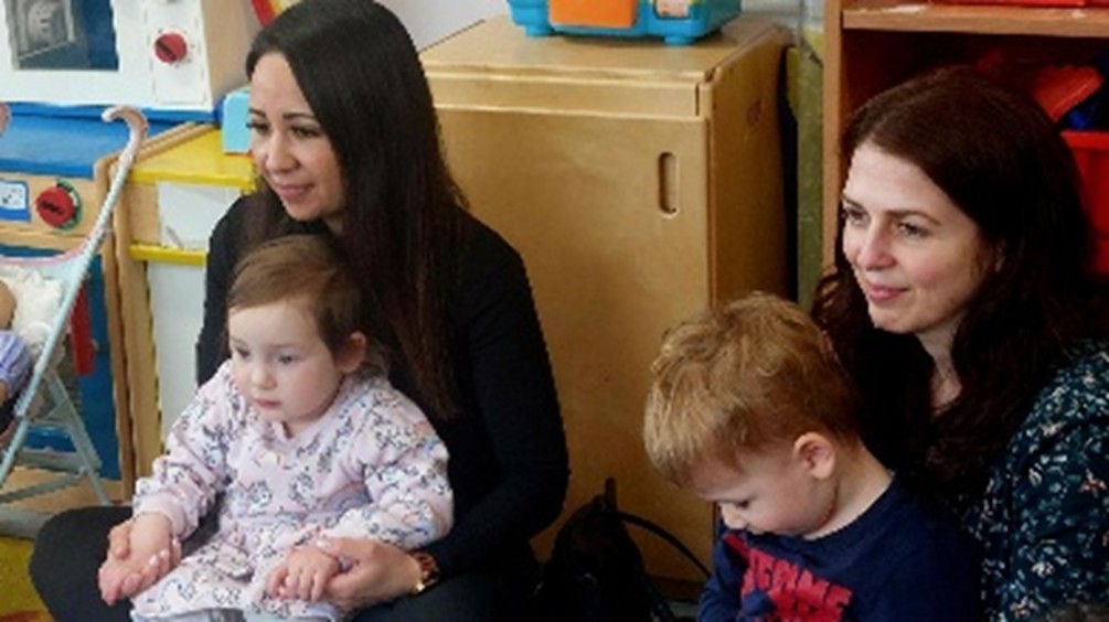 Two adults and two children sitting in a classroom