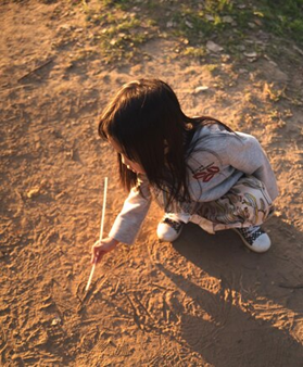 A child drawing in the san