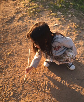 A child drawing in the sand