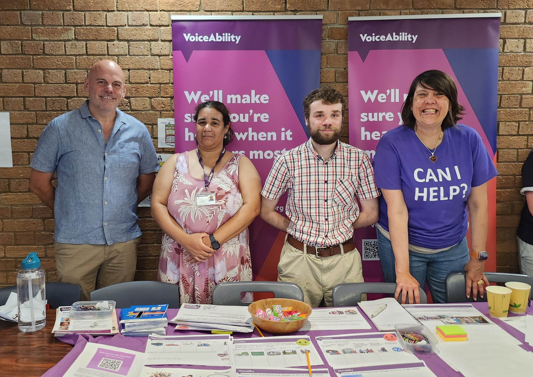Group of people at an event stall with a range of leaflets and giveaways