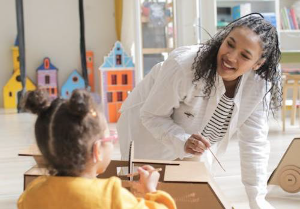 A person and a child painting cardboard