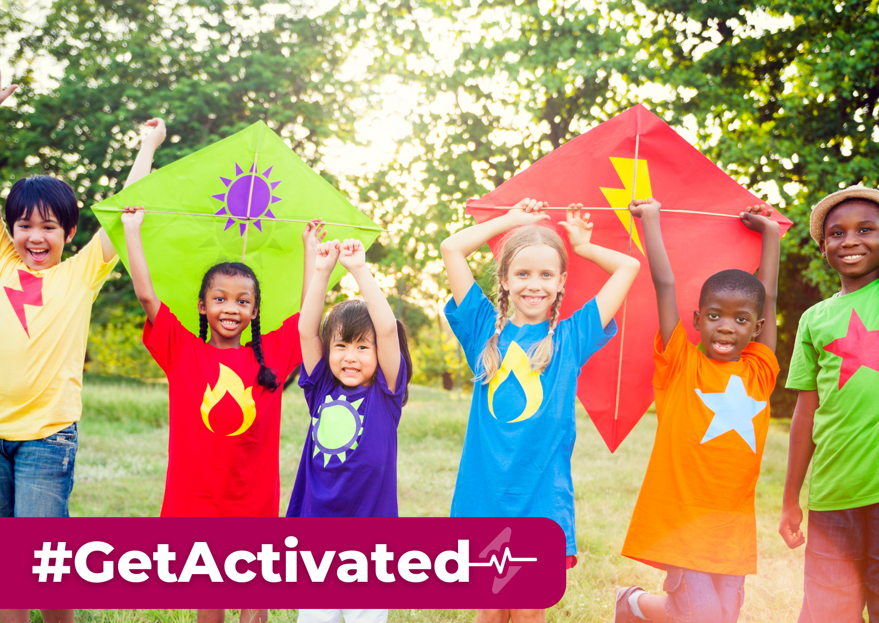 Group of children in a park in the summer wearing colourful t-shirts and holding kites