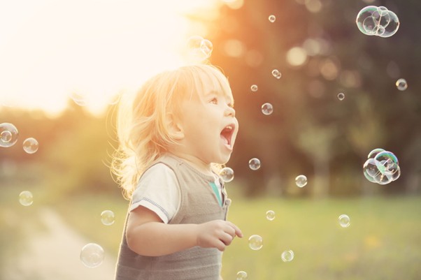 Young child outside enjoying bubbles