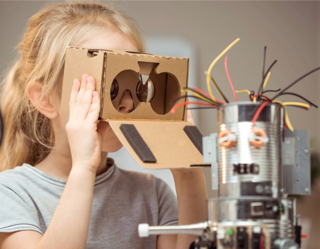 A child is looking through a cardboard box.