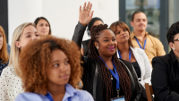 A group of people raising their hands at a conference