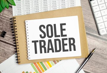 Sole trader text notebook chart with plant pen calculator