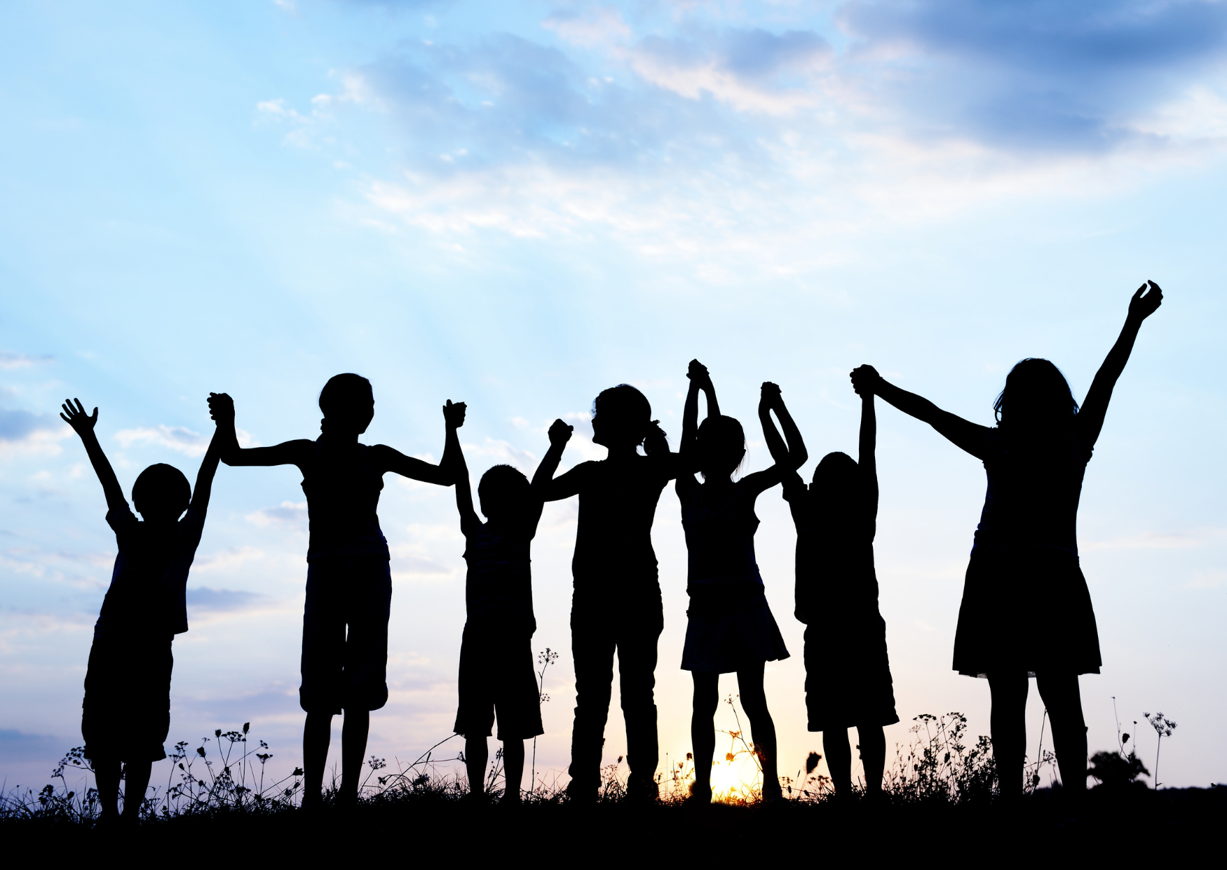 Children holding hands in a field