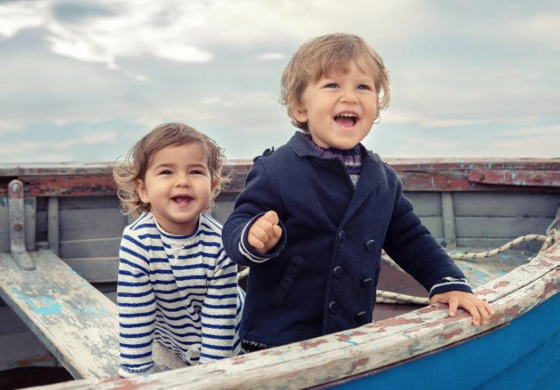 Two young children laughing on a boat