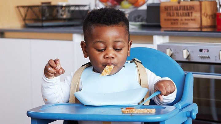 A child eating food in a high chair