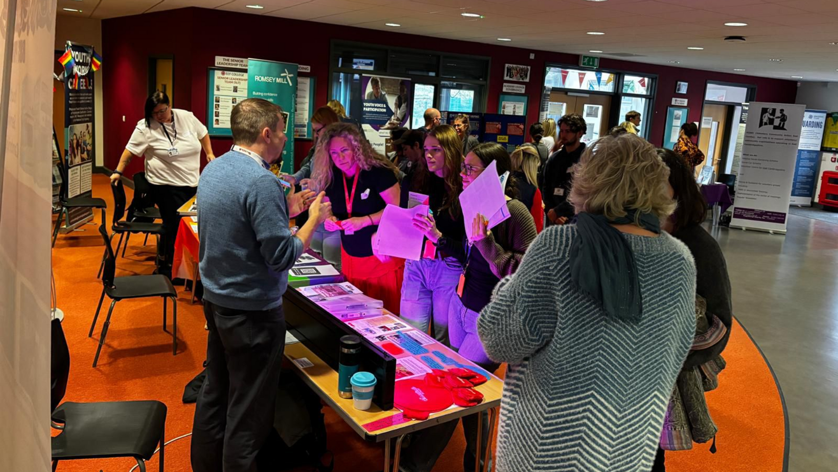 Image of a group of people stood at a stand at a conference