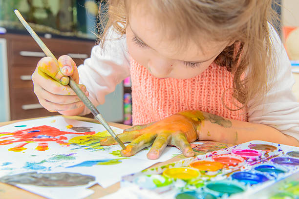 A child painting with paint on paper