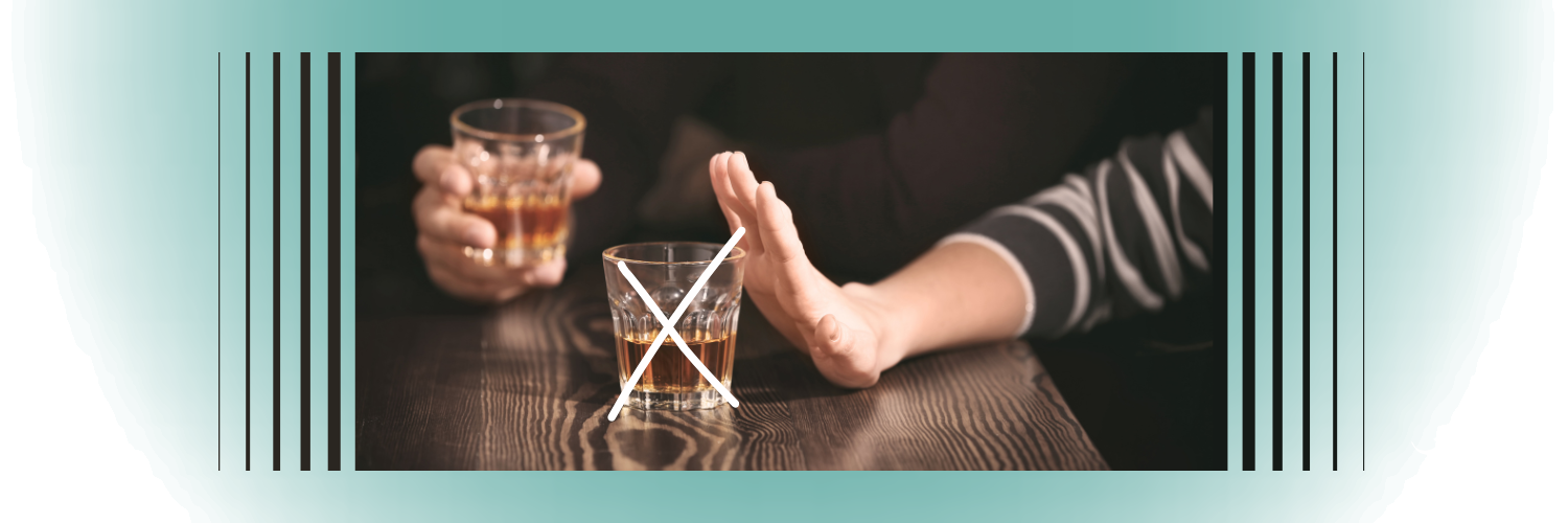 Image of a hand held up in front of a glass of alcohol, the glass has a white X symbol over it