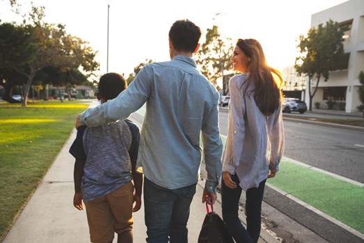 Backs of a family walking up a street