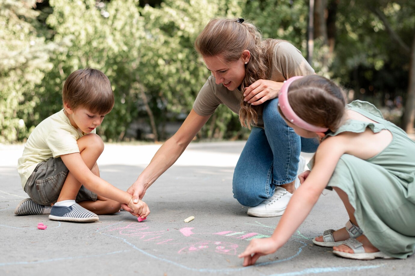 Adult and children drawing on ground