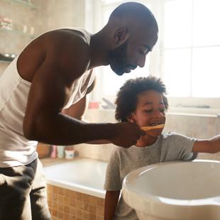 Parent brushing child's teeth
