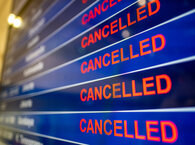 An electronic airport information board with each row displaying the word 'Cancelled'.