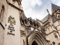 The main entrance of the Royal Courts of Justice in central London, looking up at the top of the doorway arch and the courts'name alongside.