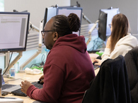 Two HM Land Registry caseworkers sitting at their desks with keyboards and screens in front of them.