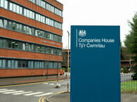 A sign saying 'Companies House' in English and Welsh, with an office building in the background.