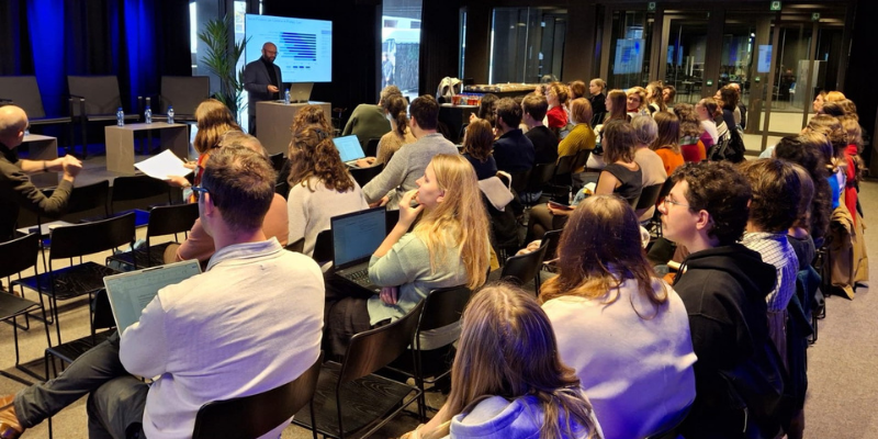 people sat and listening to a presentation in a conference room